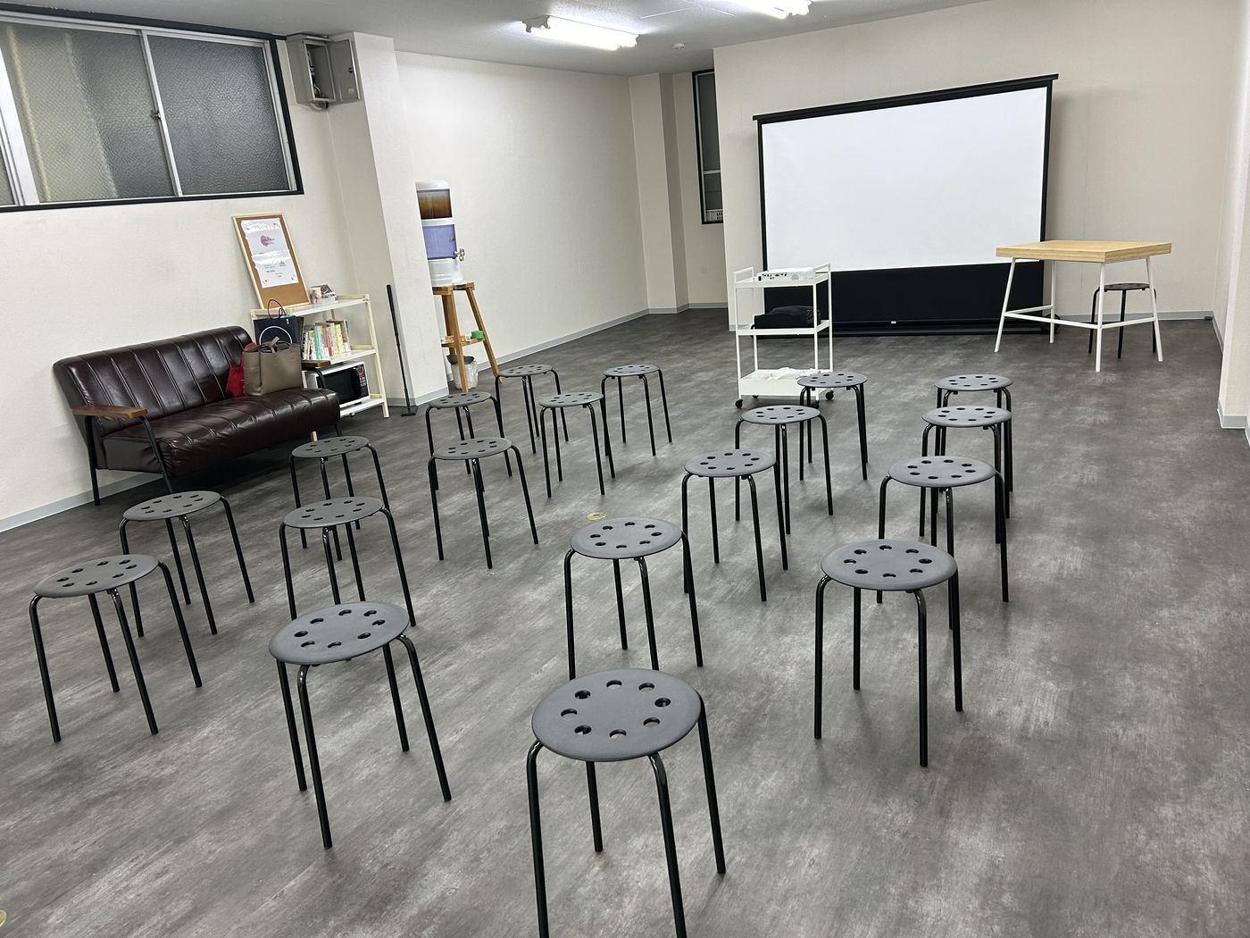 スクリーンとスツールを並べたセミナー形式のレイアウト